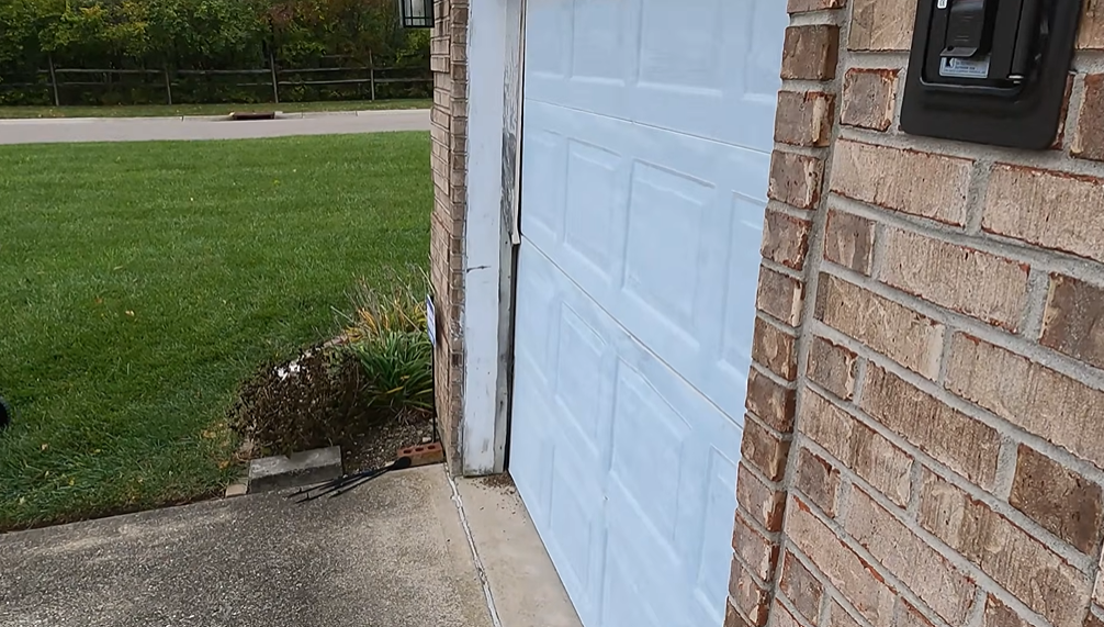 Garage door and track after repair on a brick home exterior