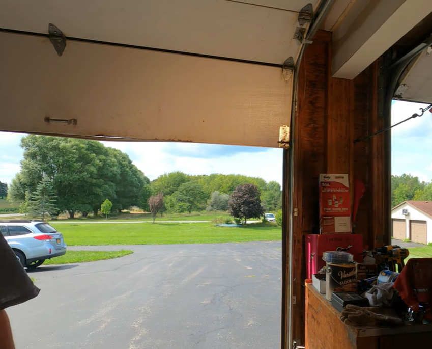 Damaged wood garage door before repair